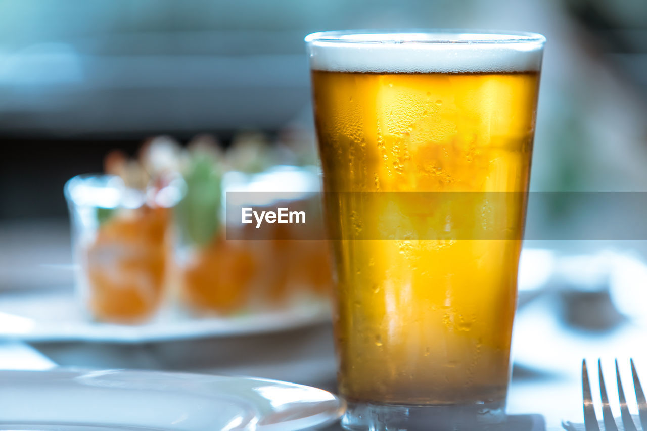 CLOSE-UP OF BEER IN GLASS