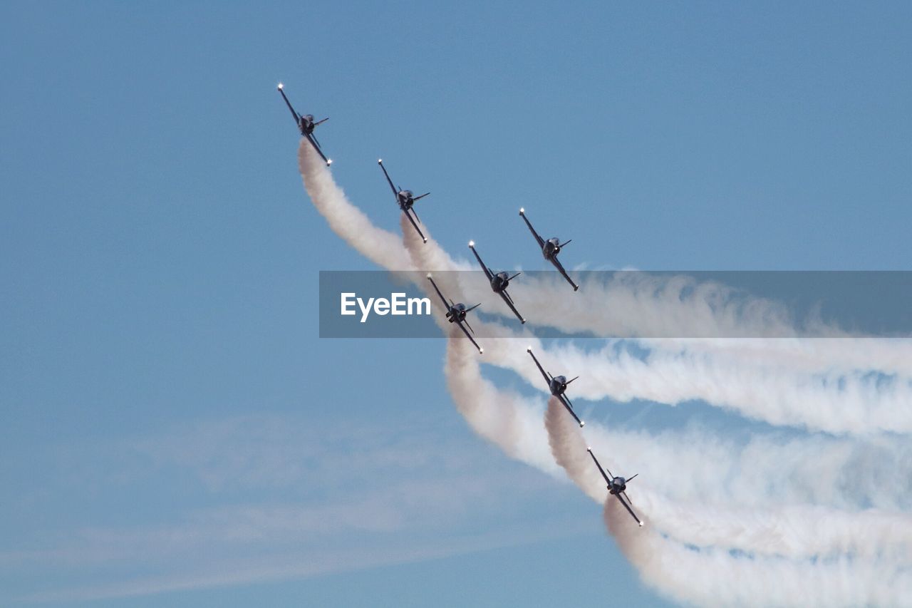 Low angle view of airshow against sky