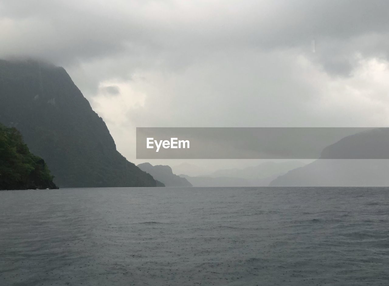 Scenic view of sea and mountains against sky