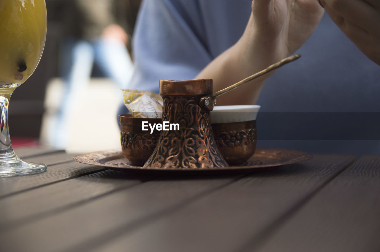Midsection of woman with containers at table
