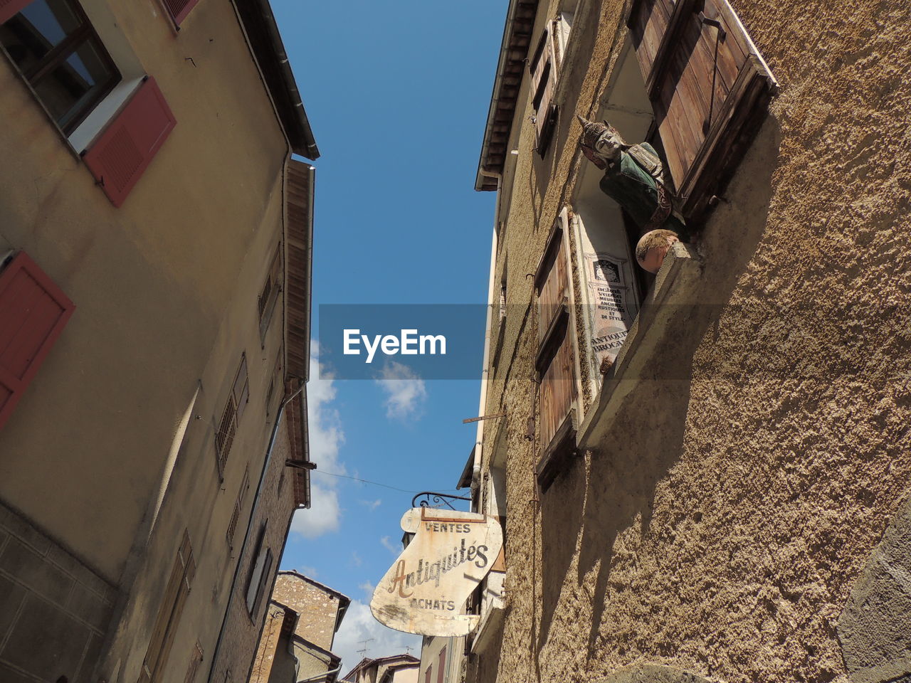 LOW ANGLE VIEW OF BUILDINGS AGAINST BLUE SKY AND CLOUDS