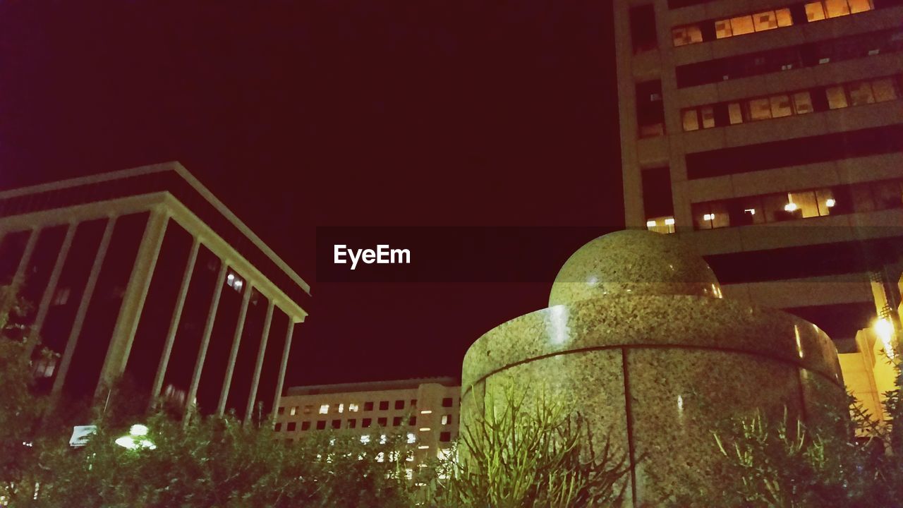 LOW ANGLE VIEW OF MODERN BUILDING AT NIGHT