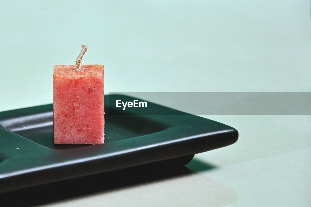 CLOSE-UP OF ICE CREAM ON TABLE AGAINST GRAY BACKGROUND