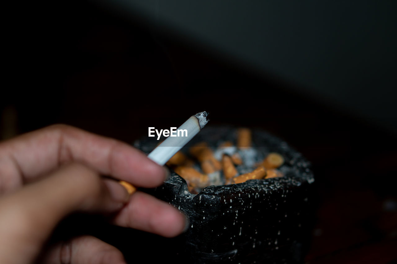 cropped hand of person holding cigarette