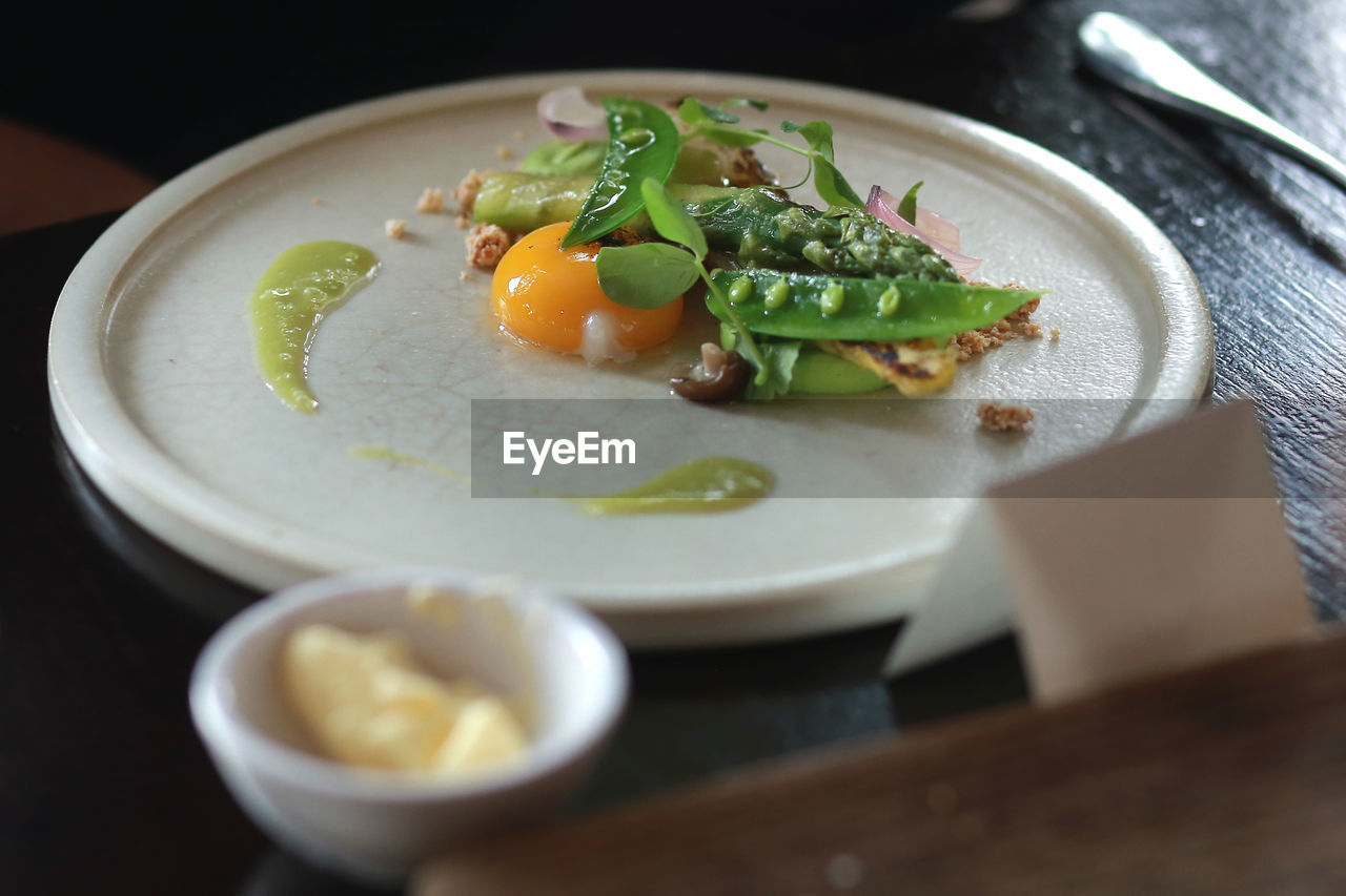 High angle view of egg yolk with vegetables served in plate