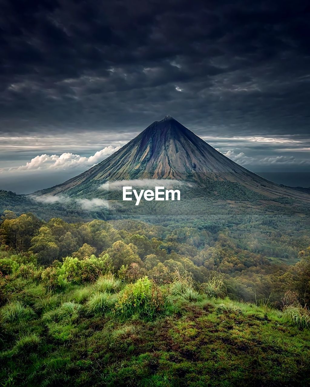 Scenic view of volcanic mountain against cloudy sky