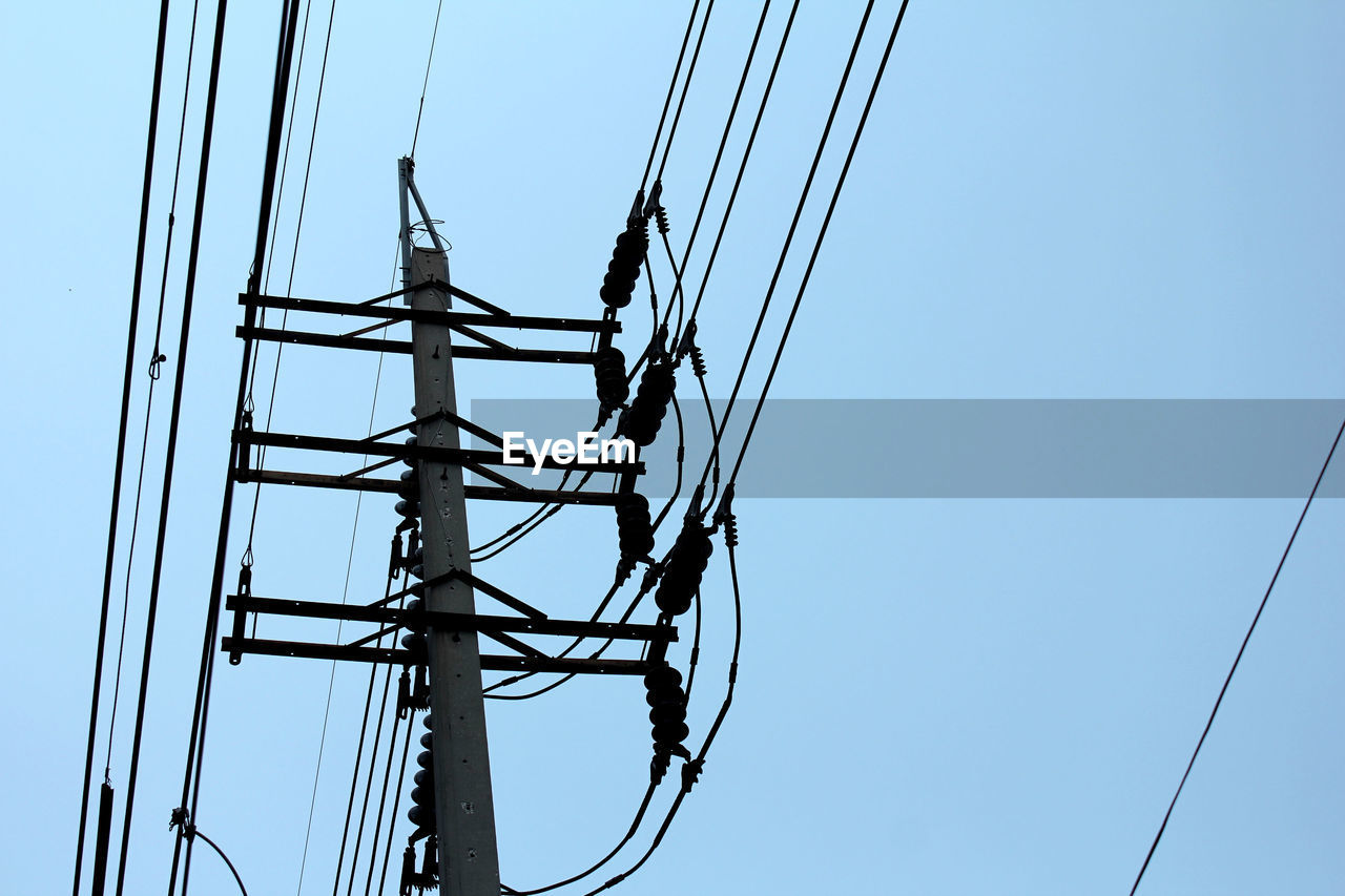 Low angle view of electricity pylon against sky