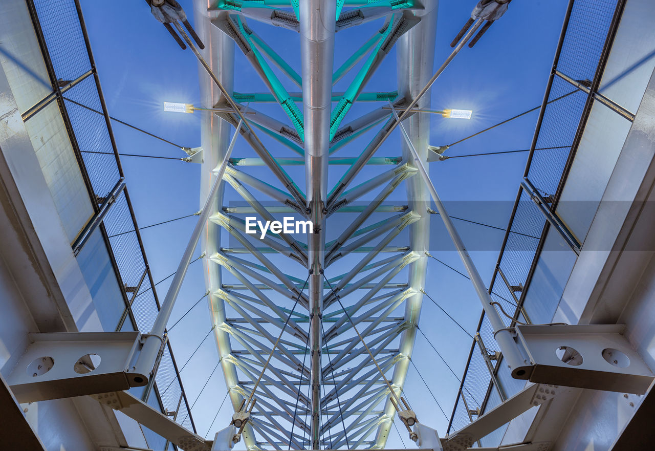 Low angle view of illuminated bridge against sky at dusk