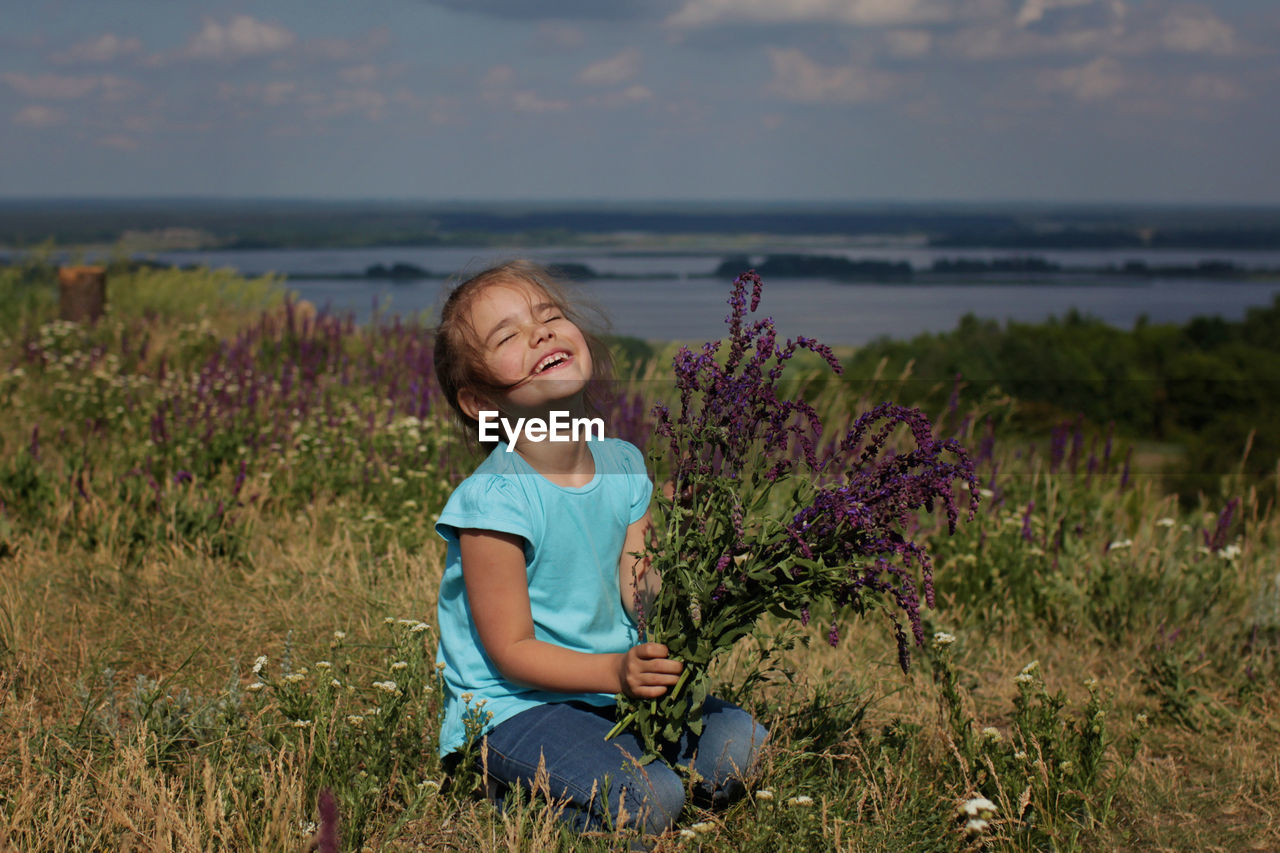 Cute 5 years girl gathering violent field flowers