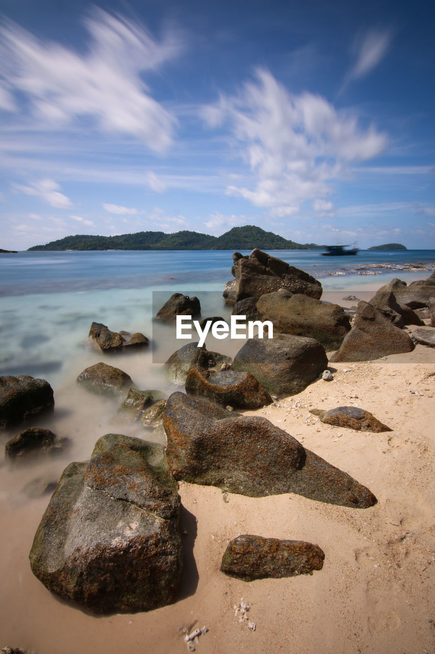 ROCKS ON SHORE AGAINST SKY