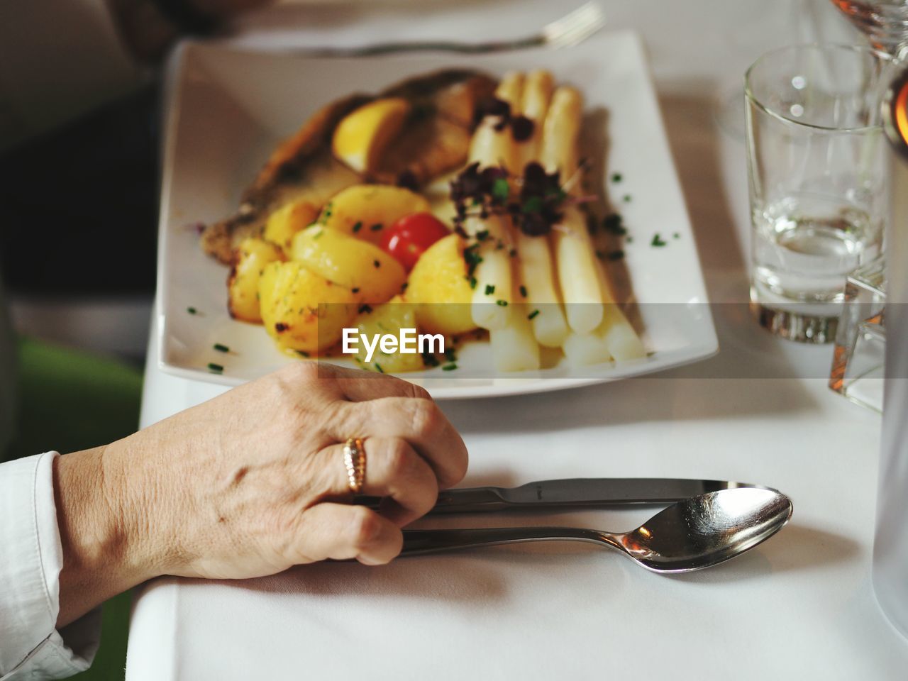 Cropped hand by food on table