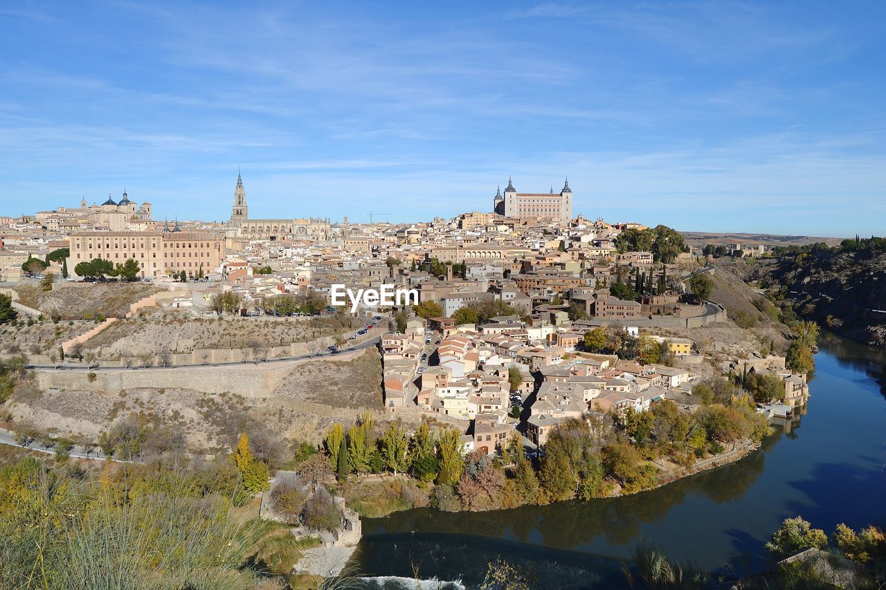 View of castle by river against blue sky