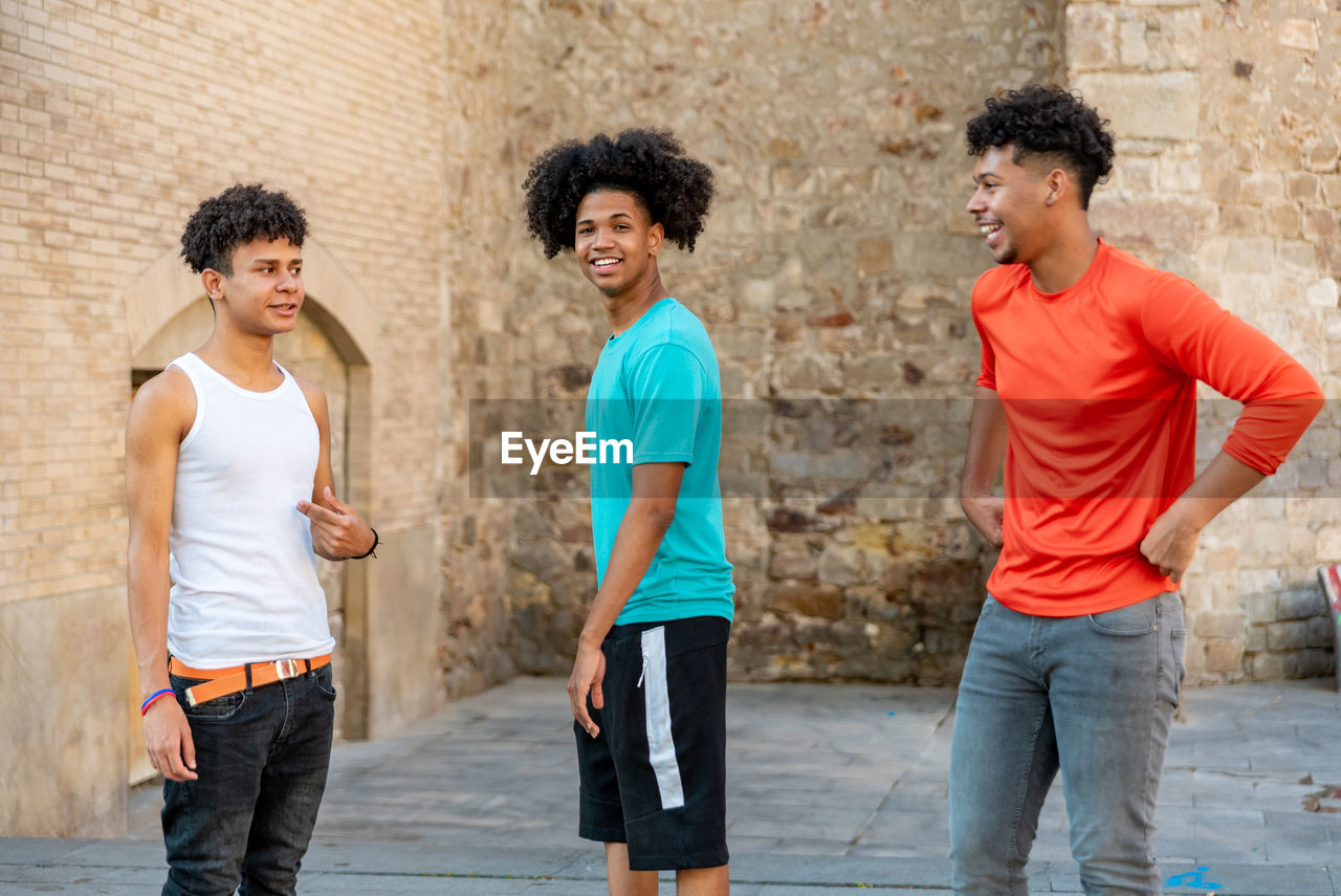 Group of afro latin male friends dancing in the street