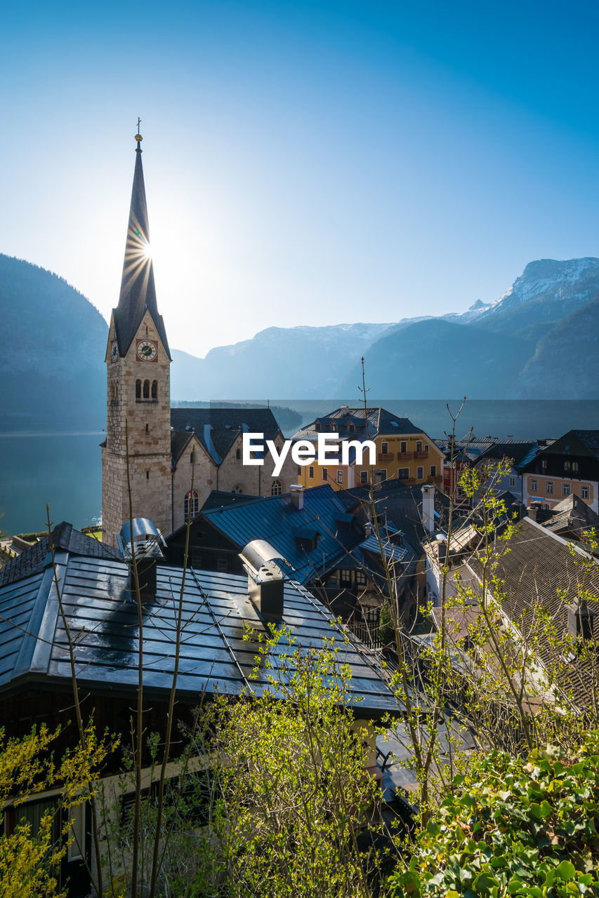 CHURCH BY BUILDINGS AGAINST SKY