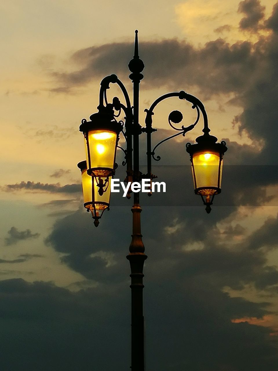 LOW ANGLE VIEW OF STREET LIGHT AGAINST SKY AT SUNSET
