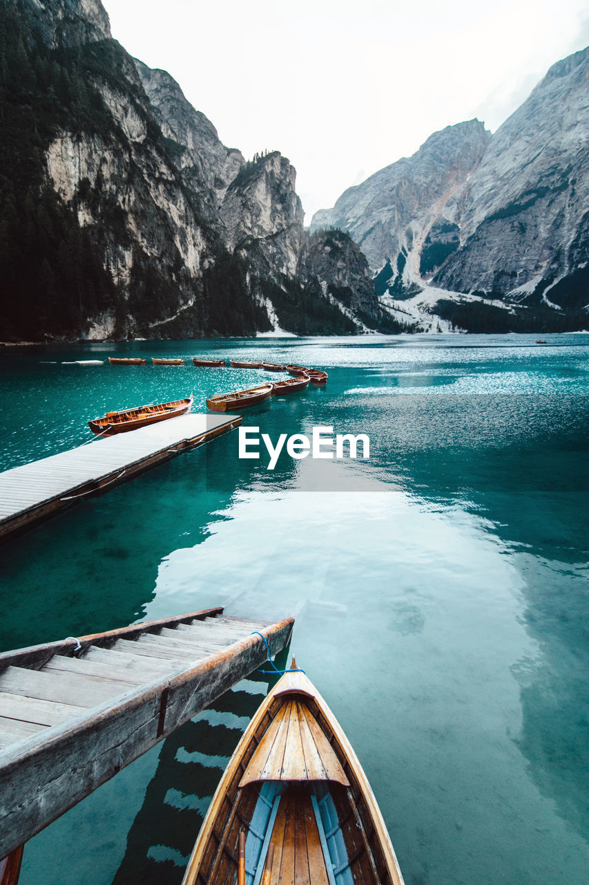 From above wooden quay on amazing scenery of lake with turquoise water in mountains on foggy day