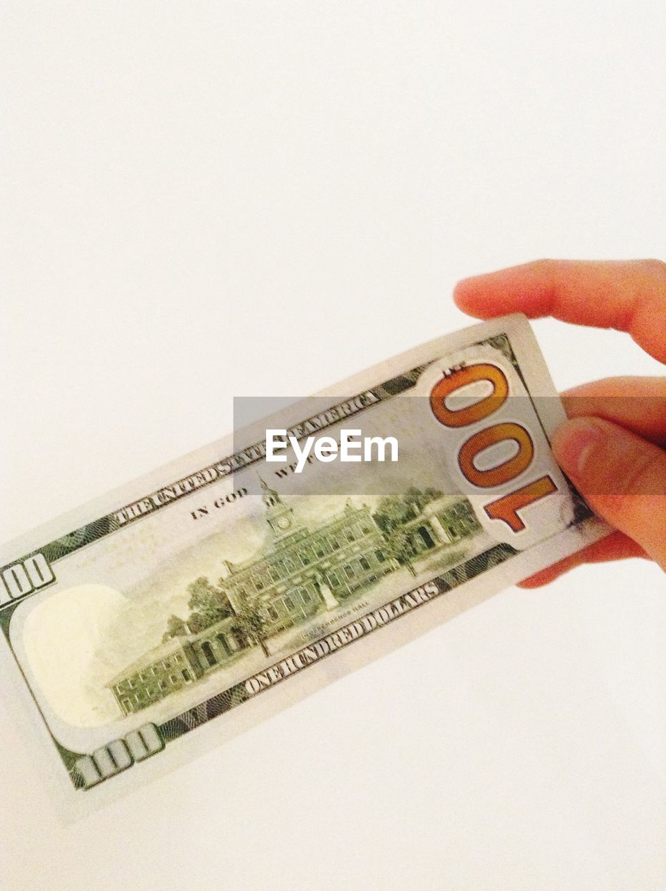 Cropped image of hand holding one hundred dollar against white background