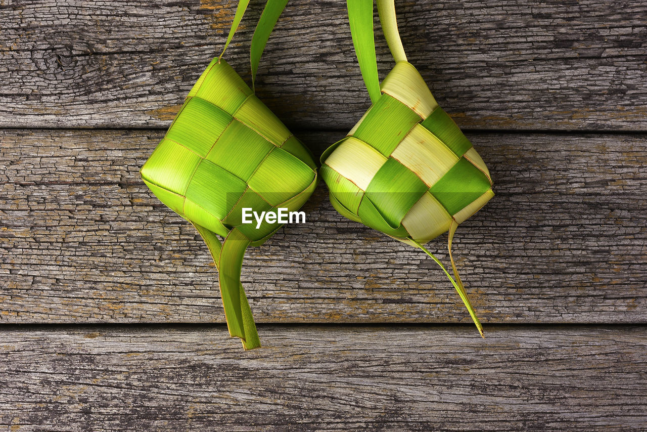 Close-up of ketupat made from coconut leaf on white background
