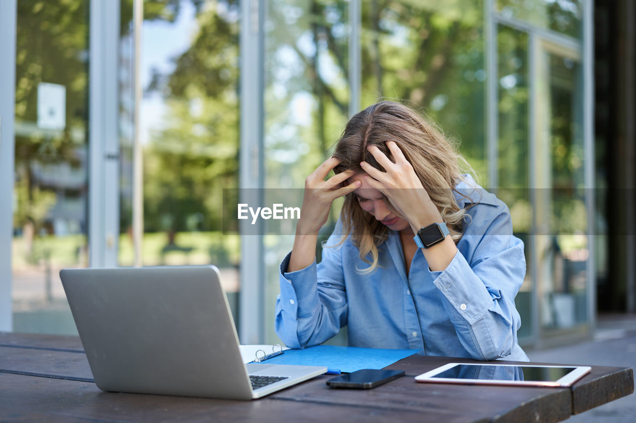 young woman using mobile phone while sitting in office