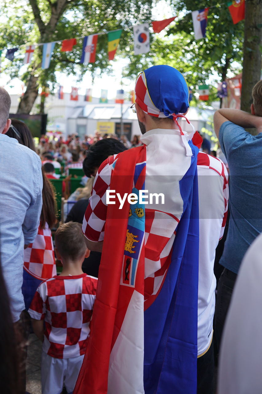 REAR VIEW OF PEOPLE STANDING BY TRADITIONAL CLOTHING