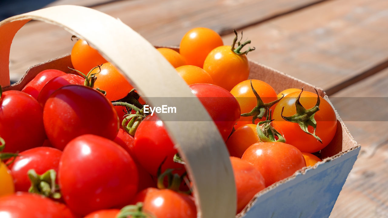 food, food and drink, healthy eating, tomato, vegetable, fruit, freshness, wellbeing, produce, red, plant, plum tomato, container, wood, no people, nature, large group of objects, close-up, ripe, organic, agriculture, basket, group of objects, cherry tomato, sunlight, juicy, multi colored