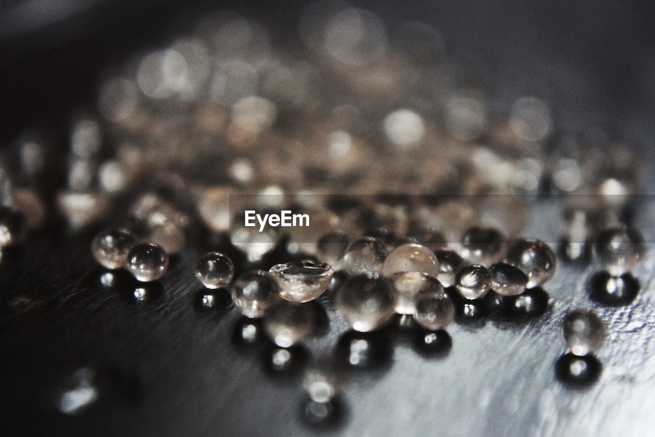 CLOSE-UP OF WATER DROPS ON GLASS TABLE