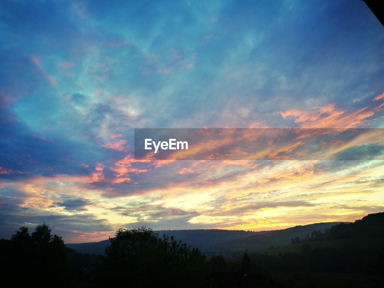 SCENIC VIEW OF SILHOUETTE MOUNTAINS AGAINST DRAMATIC SKY