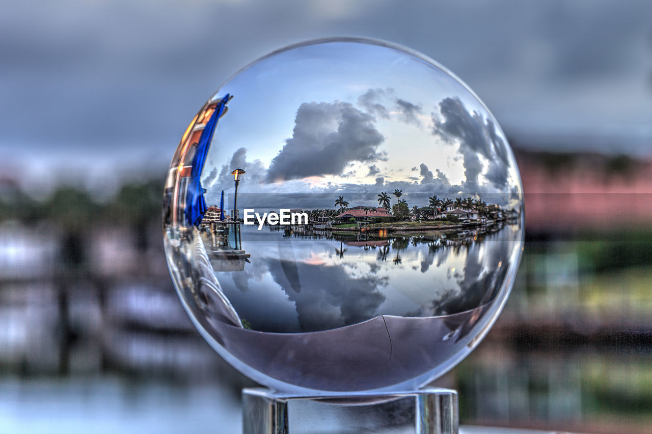 Crystal ball view of sunrise at a waterway of venetian bay in naples, florida at sunrise.