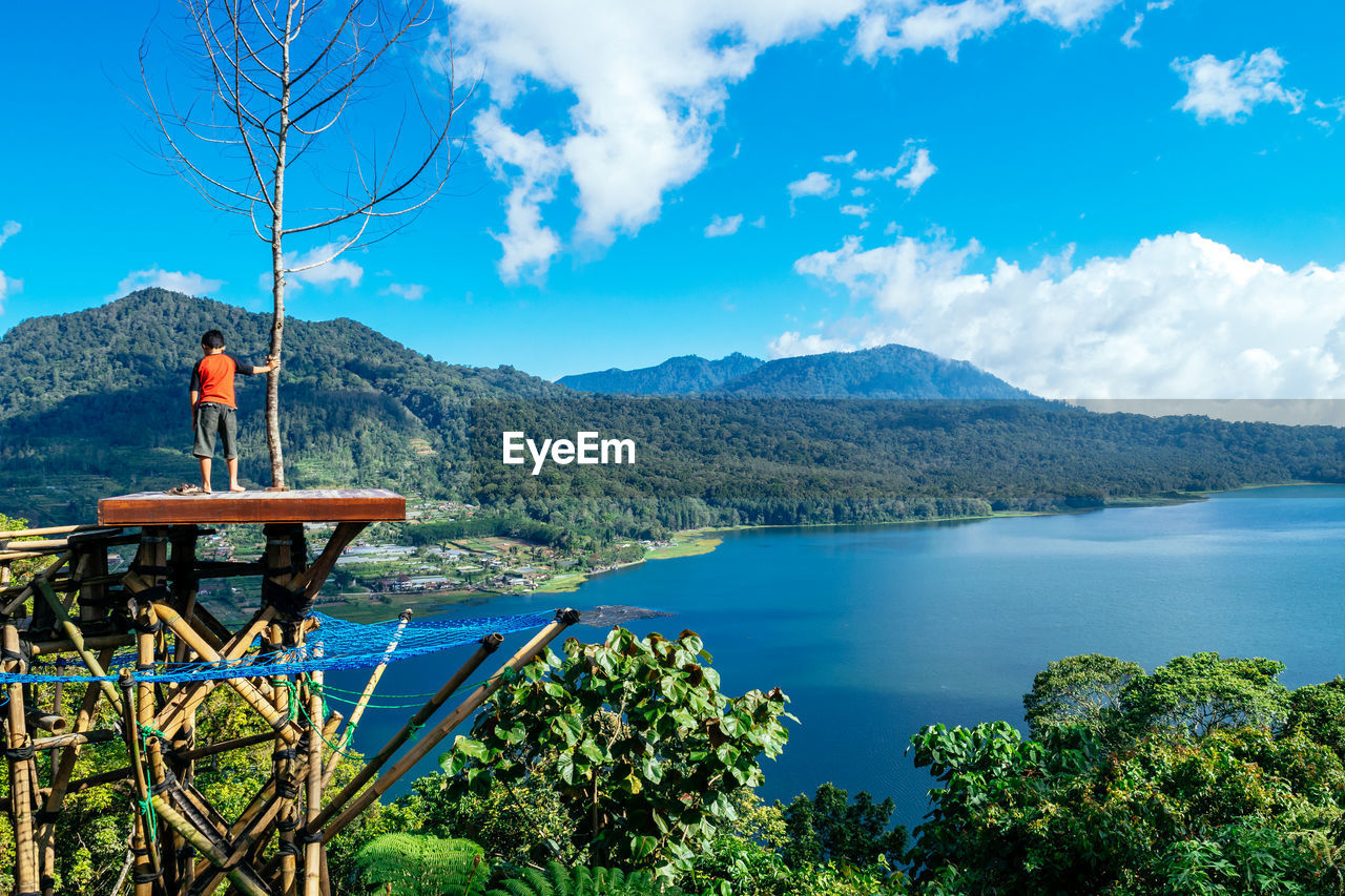 MAN LOOKING AT VIEW OF MOUNTAINS