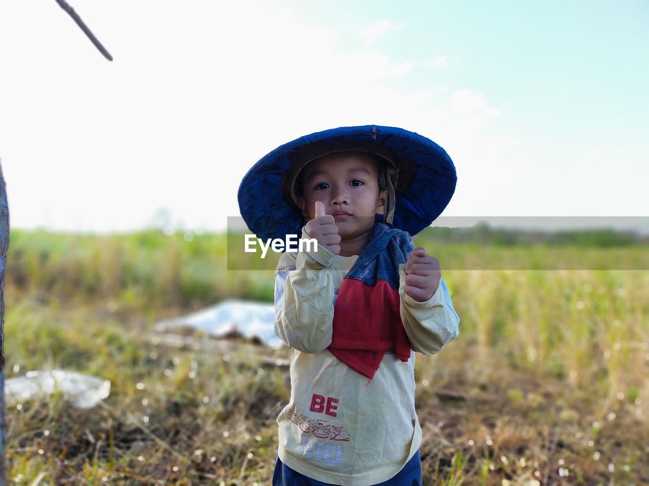 Portrait of boy wearing hat standing on field