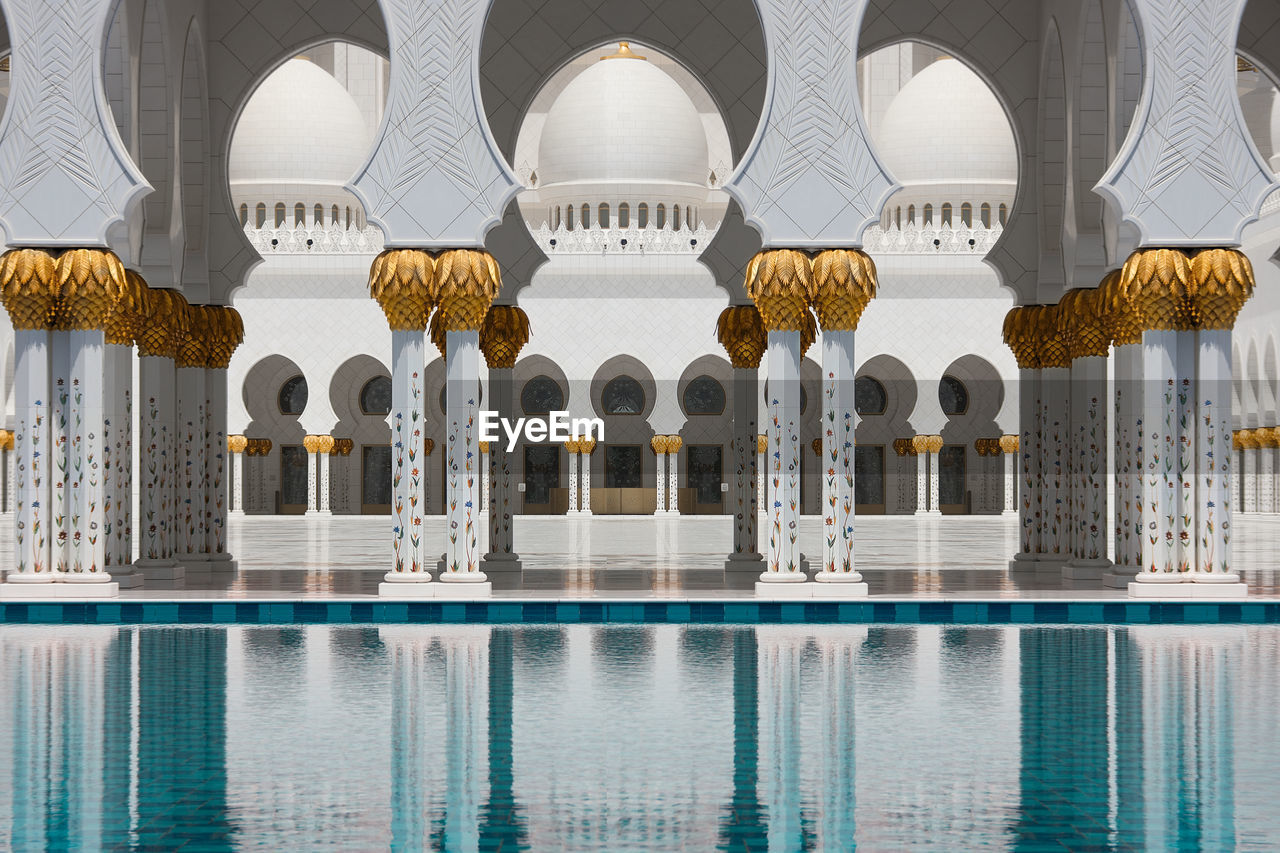 Columns of grand mosque reflecting on pool