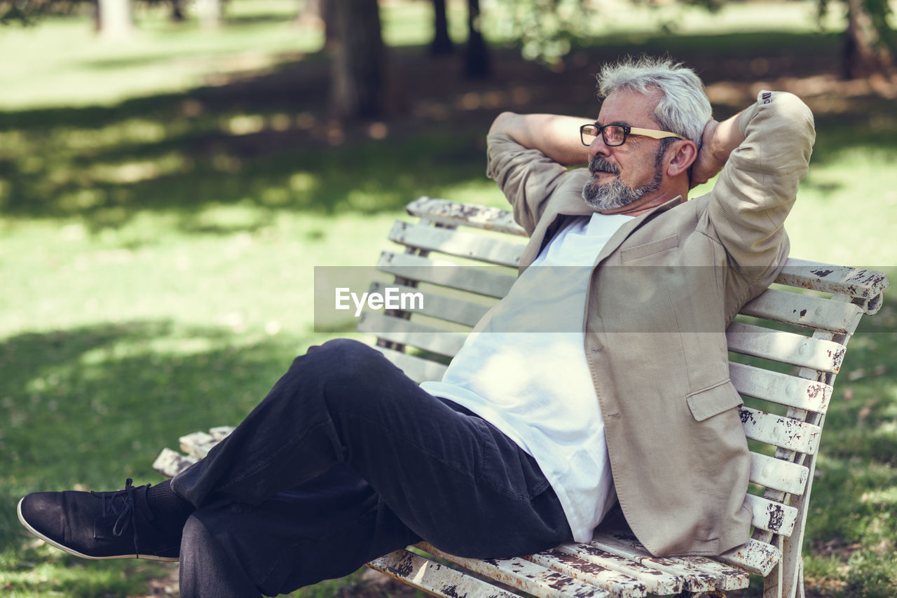 Mature man sitting on bench at park