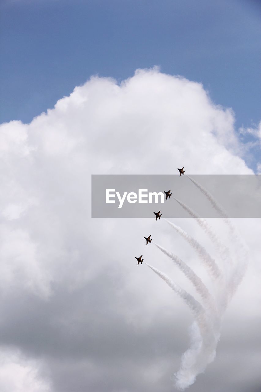 LOW ANGLE VIEW OF AIRSHOW IN MID-AIR AGAINST SKY