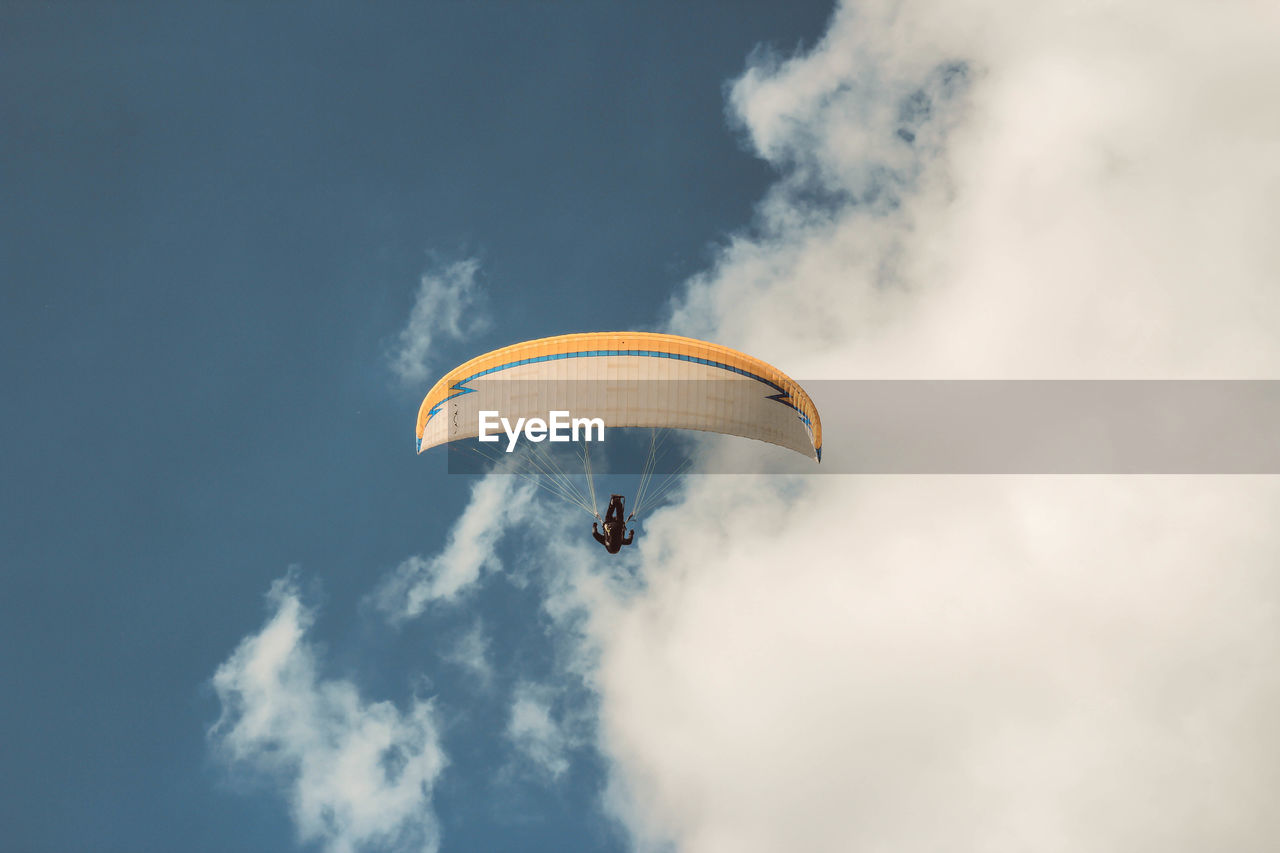 Low angle view of person paragliding in sky