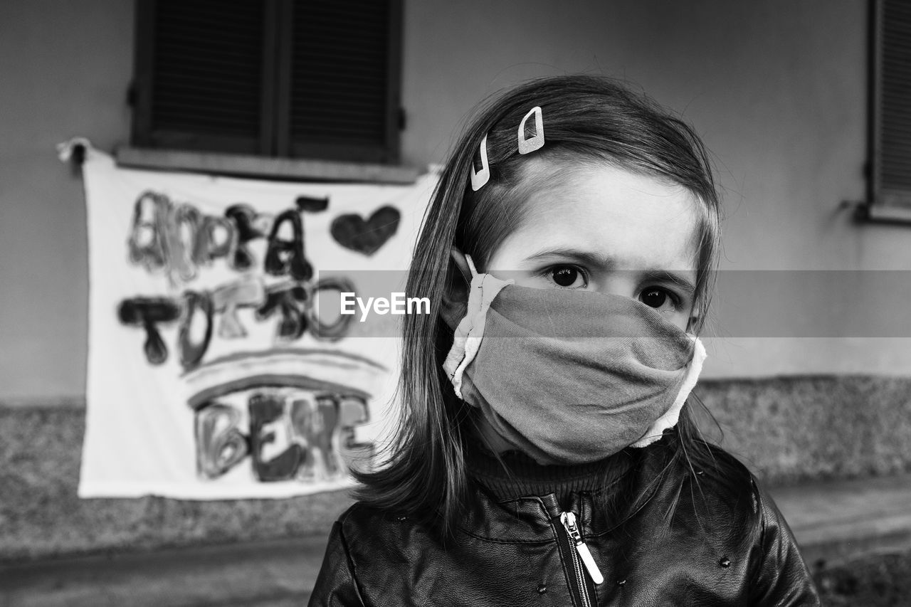 Close-up portrait of girl wearing mask outdoors