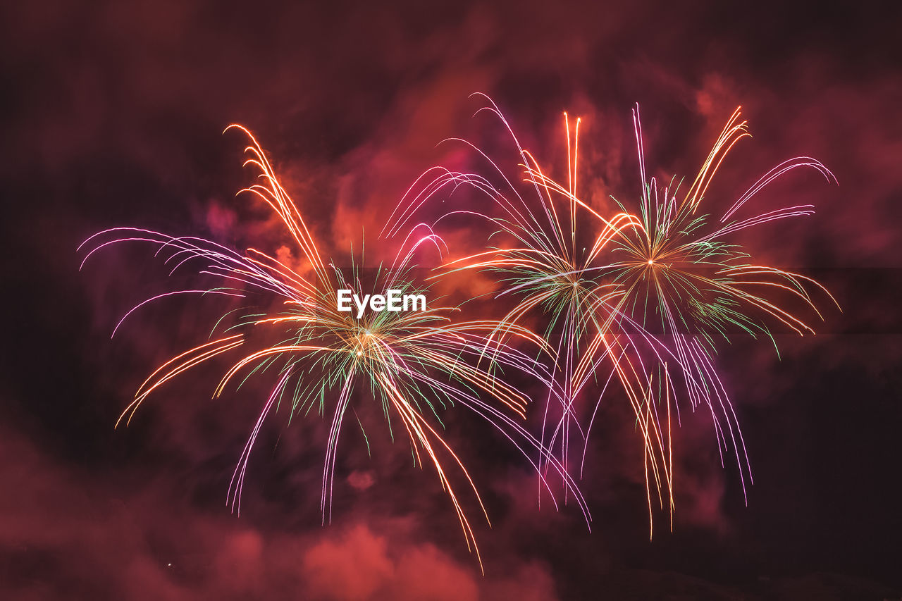 Wonderful couple of red fireworks on the feast of the patron saint of vittorio veneto, italy 