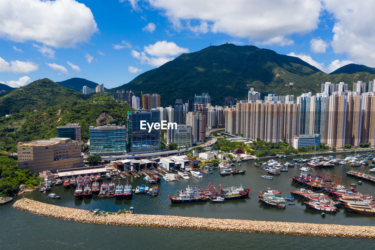 BOATS MOORED IN BAY AGAINST BUILDINGS IN CITY