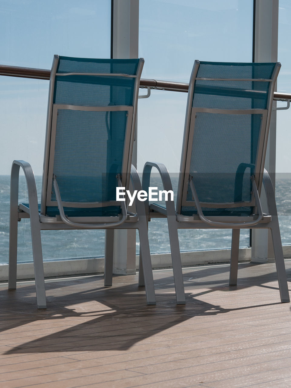 CHAIRS AND TABLE AGAINST SEA
