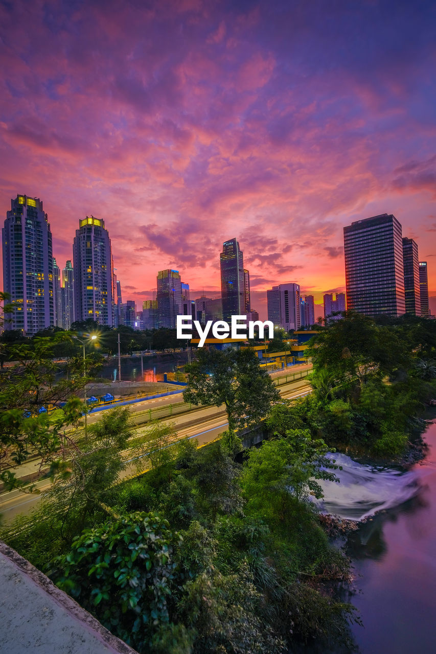 Buildings in city against sky during sunset