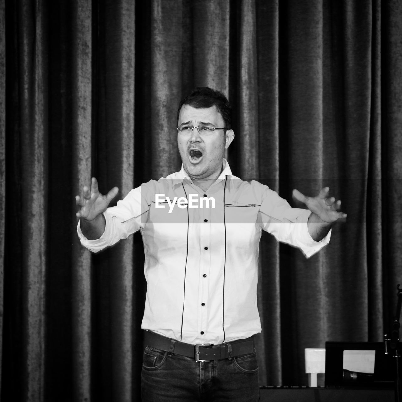 Man performing on stag against curtains