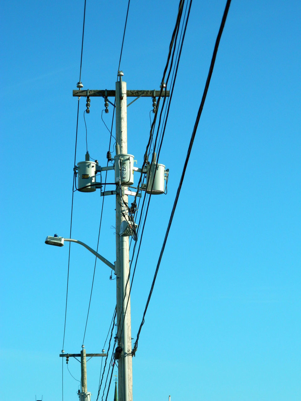 LOW ANGLE VIEW OF ELECTRICITY PYLONS AGAINST CLEAR BLUE SKY