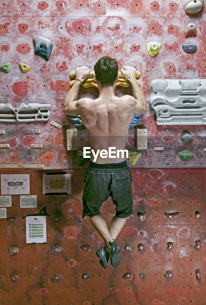 Man training on fingerboard at indoor climbing gym