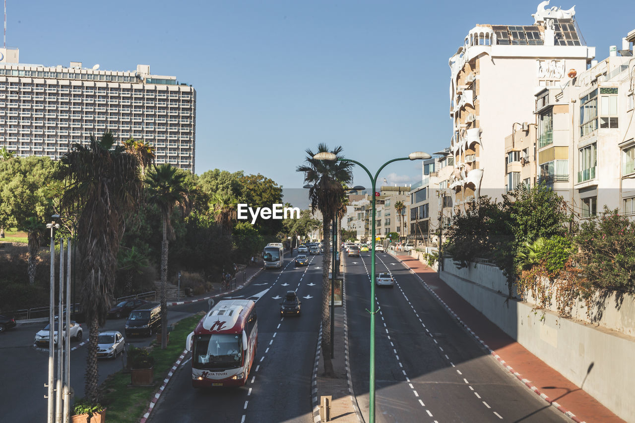 CARS ON STREET BY BUILDINGS AGAINST SKY