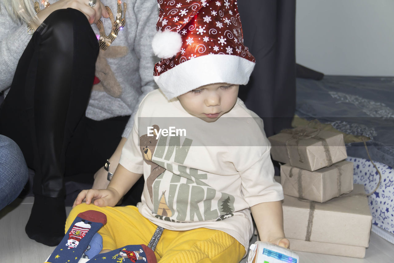Cute boy wearing santa hat playing with toy 