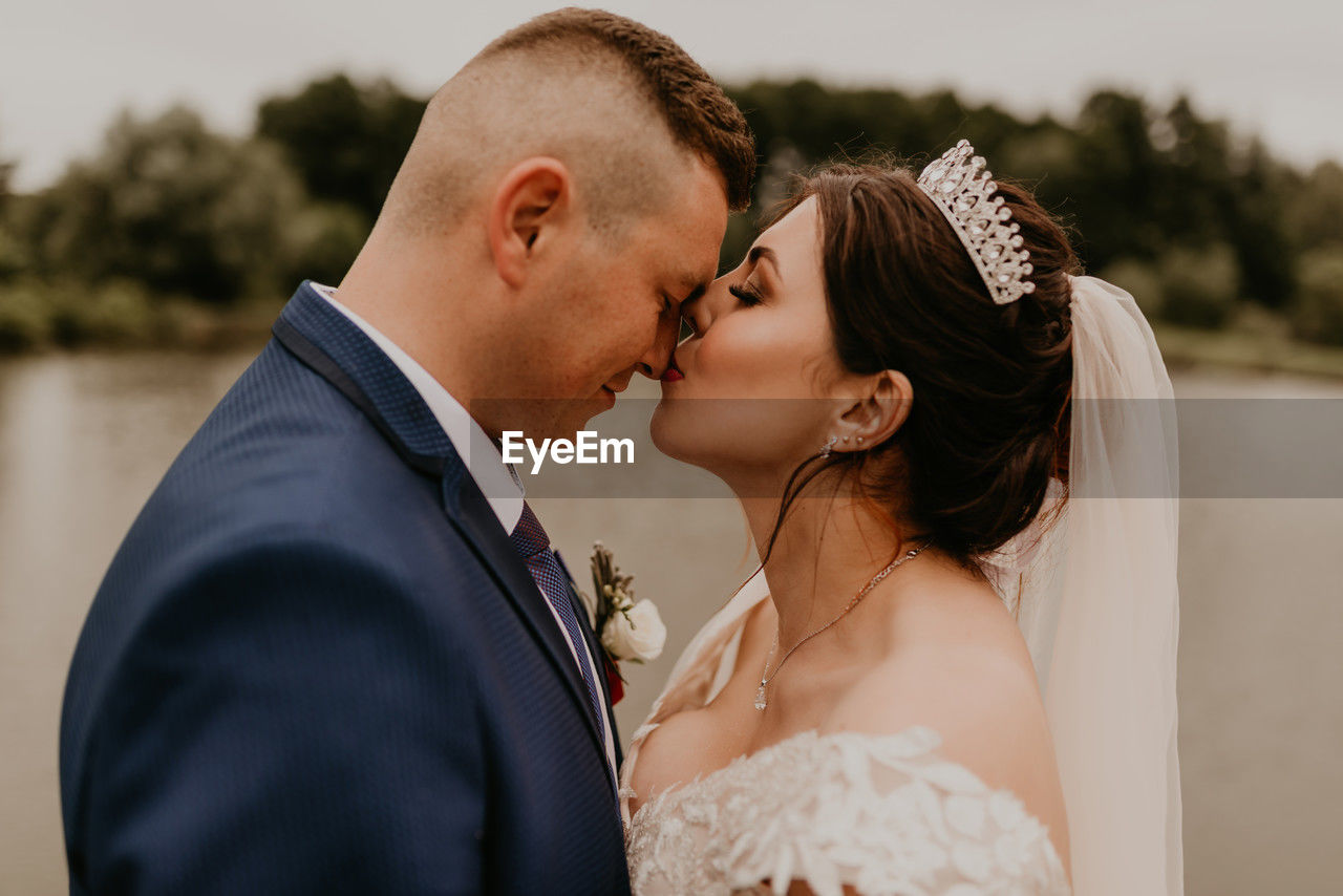 side view of bride and bridegroom holding hands