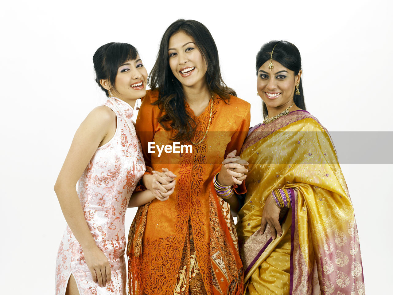 Portrait of happy young friends standing against white background