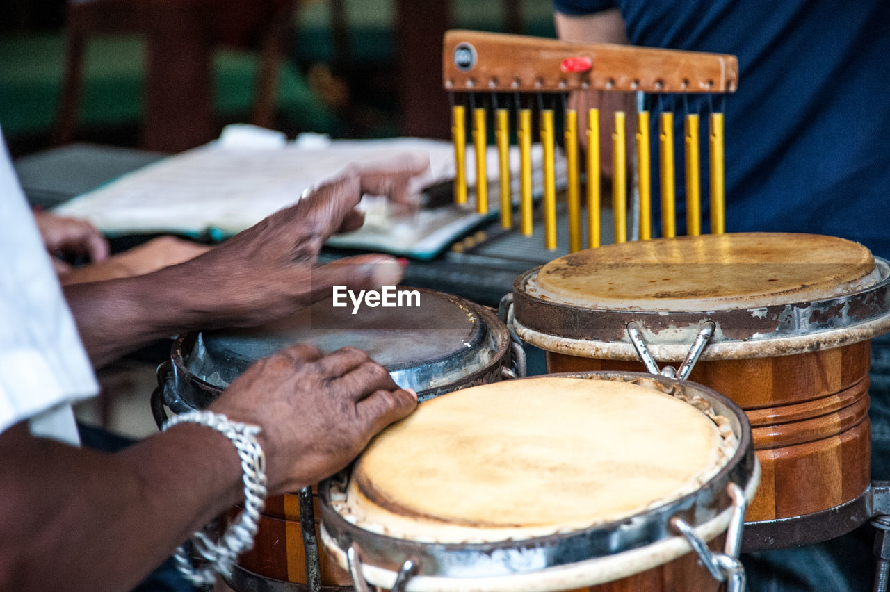 Cropped hands of man playing musical instruments