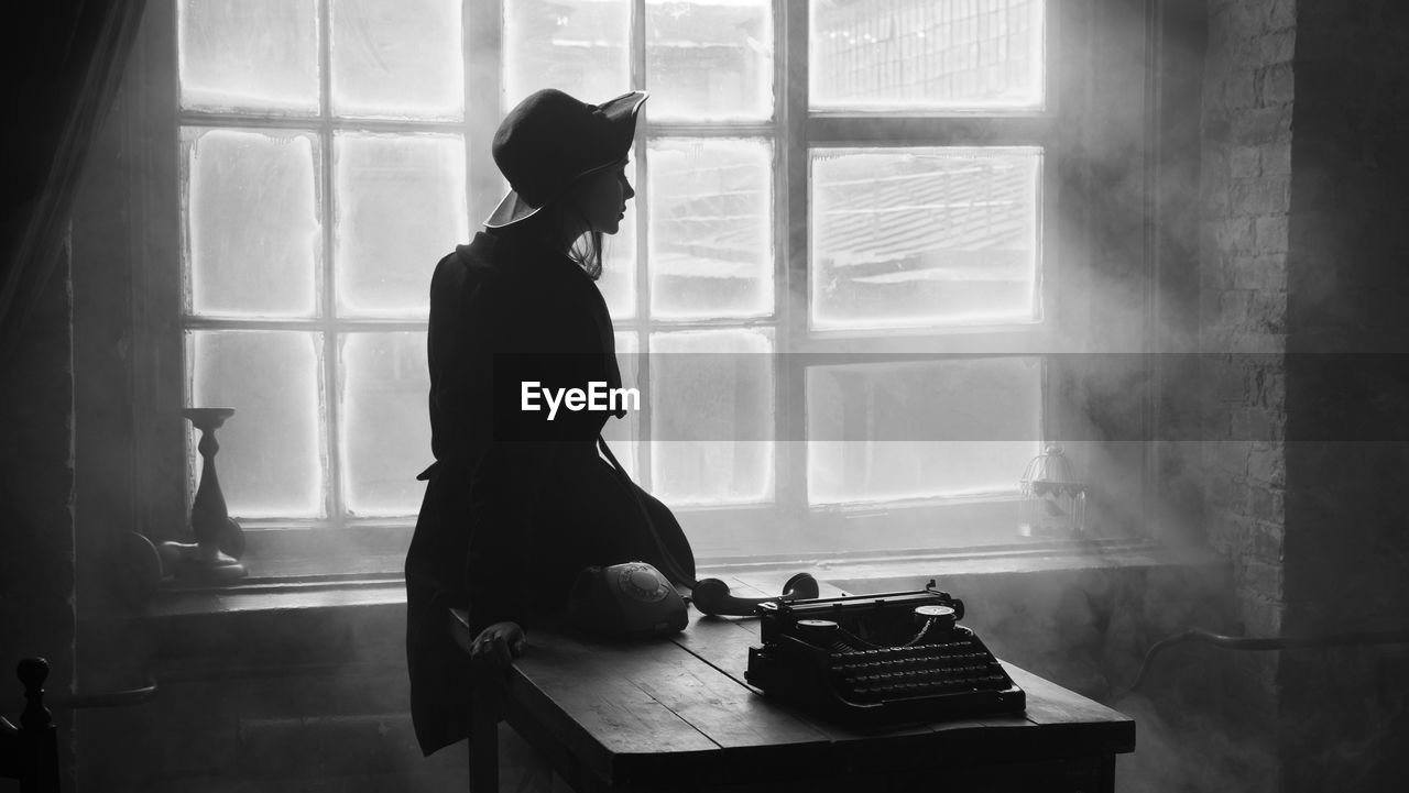 Woman sitting on table at home