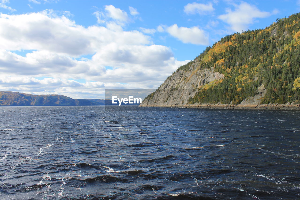 Scenic view of saguenay river and mountains against blue sky