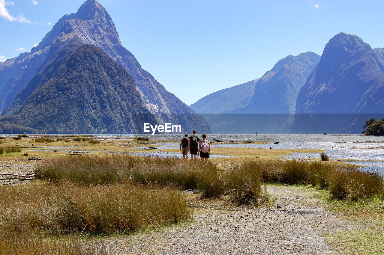 Rear view of people walking on country landscape